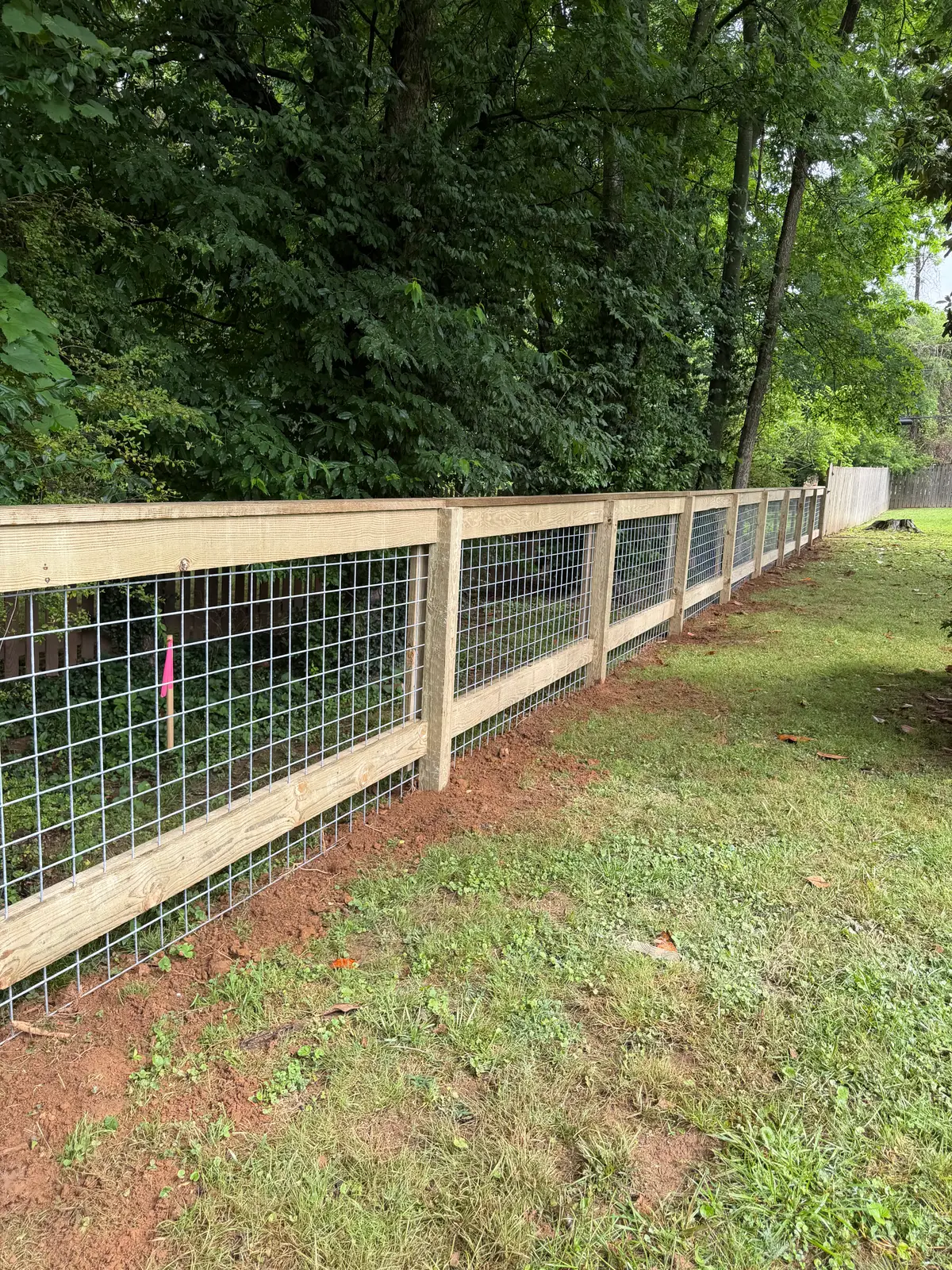 Woven-wire fence with wood posts enclosing a large field