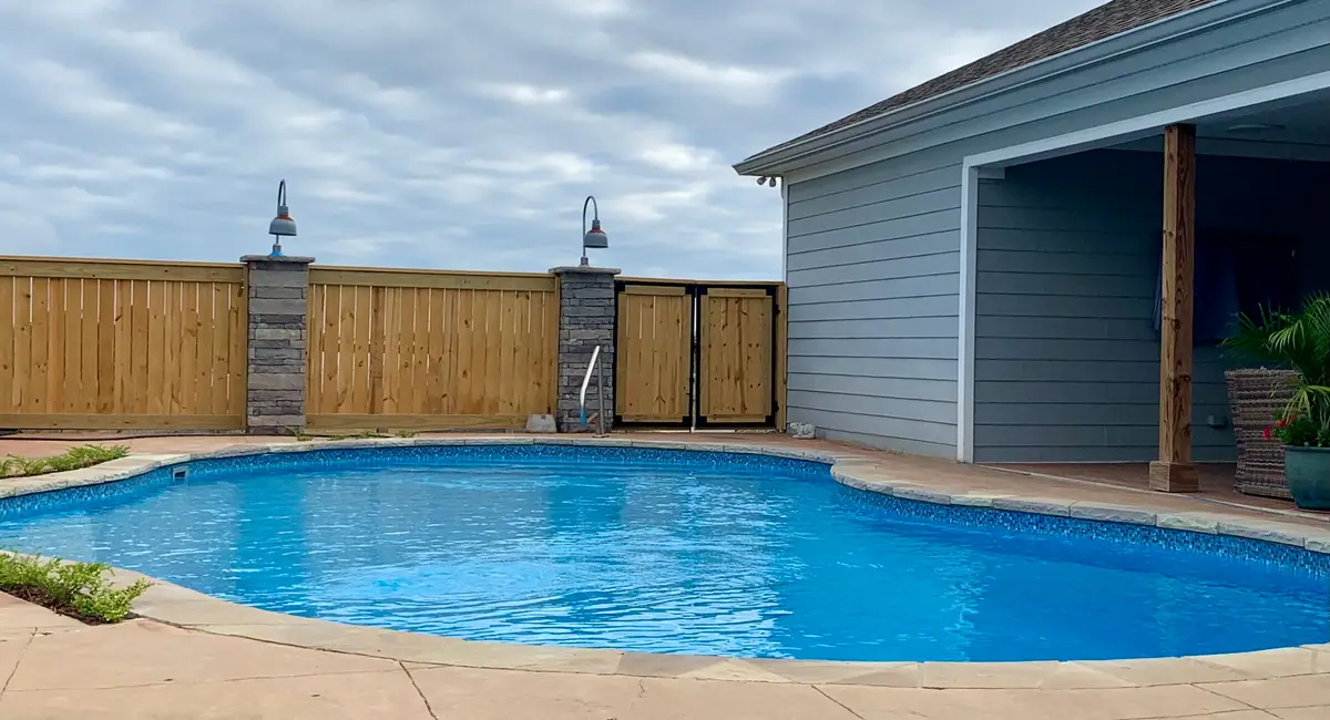 Wood privacy fence around an in-ground pool
